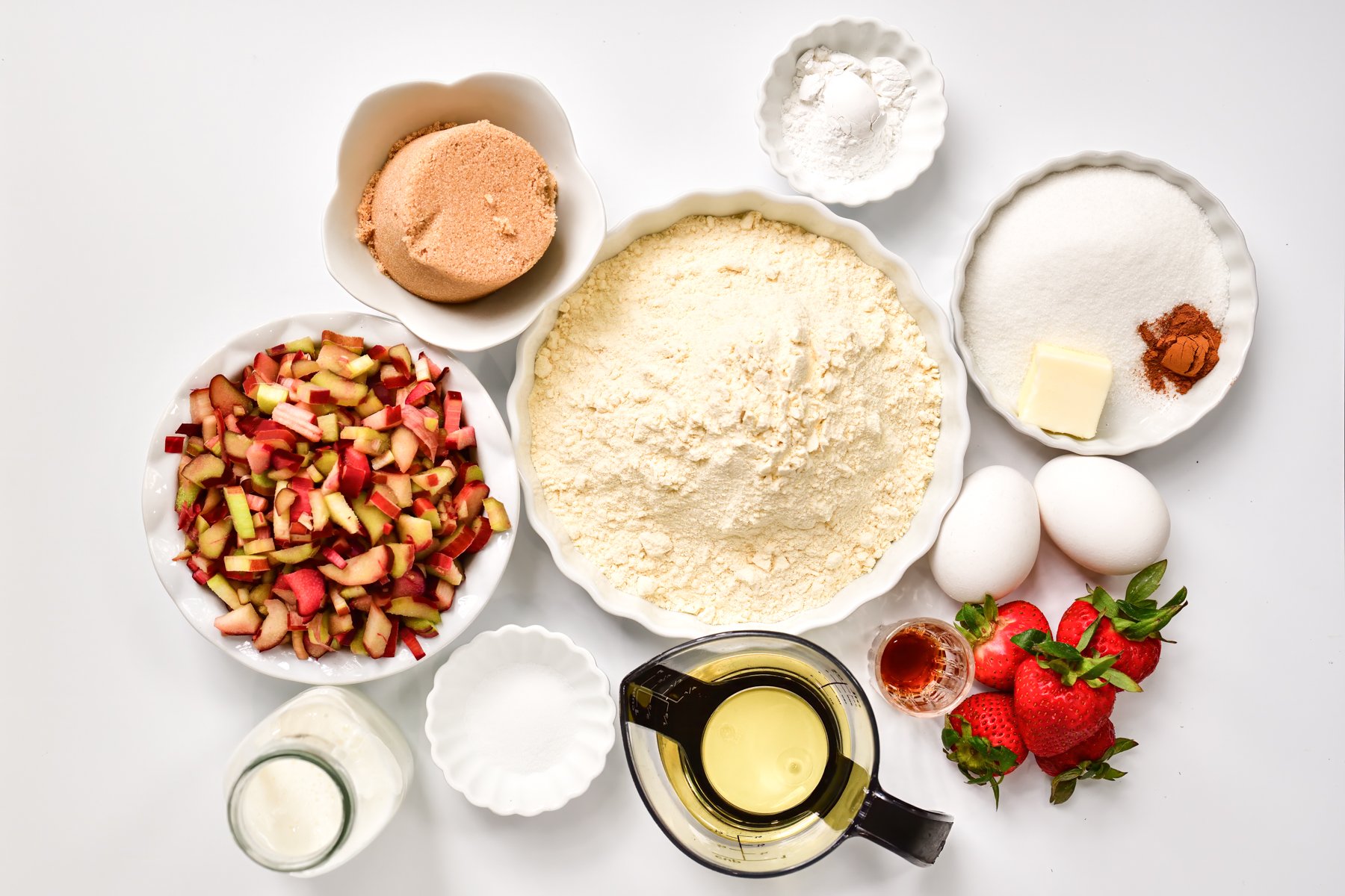 Strawberry Rhubarb muffin Ingredients in white bowls arranged on a white background