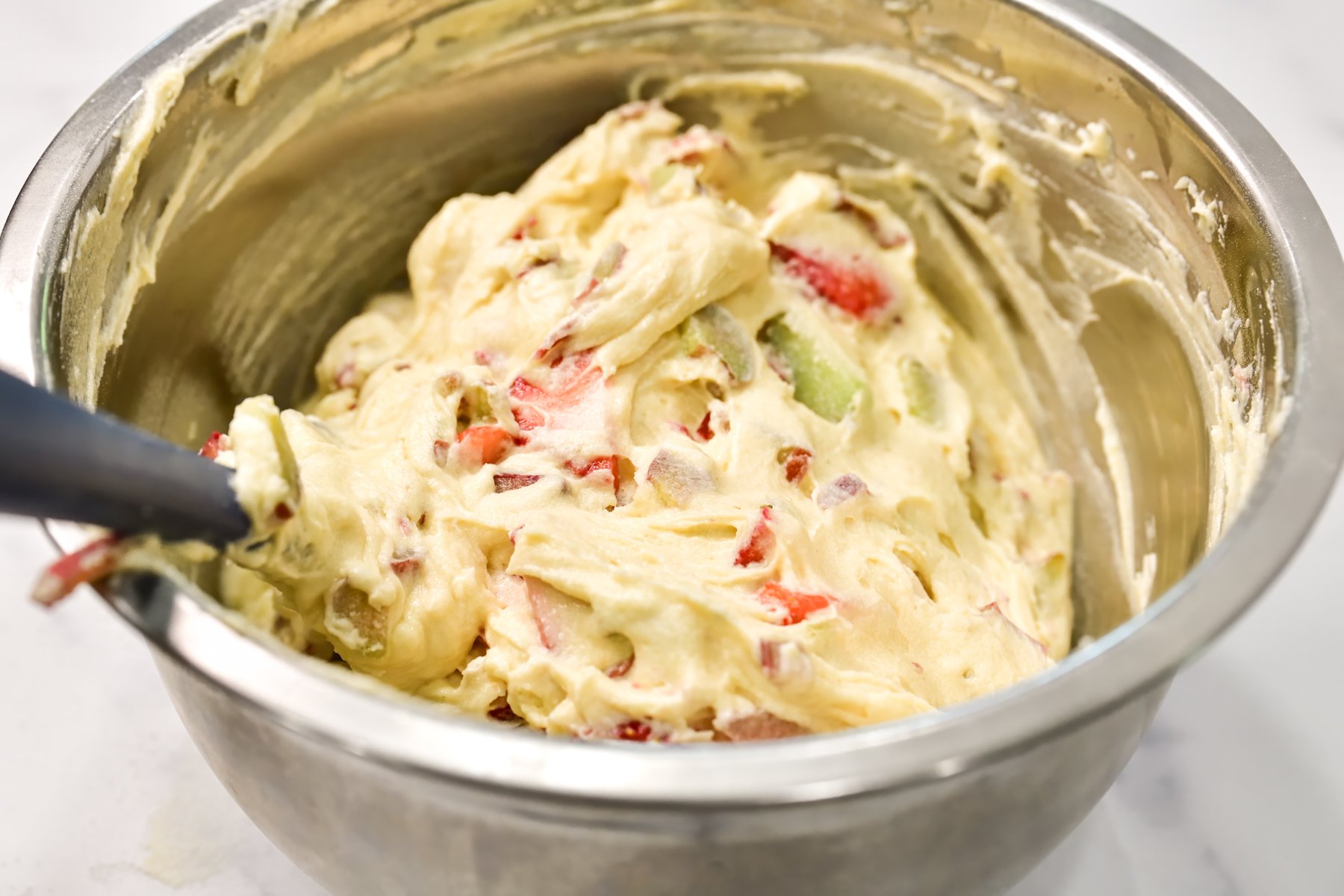 Rhubarb coffee cake batter in a silver mixing bowl